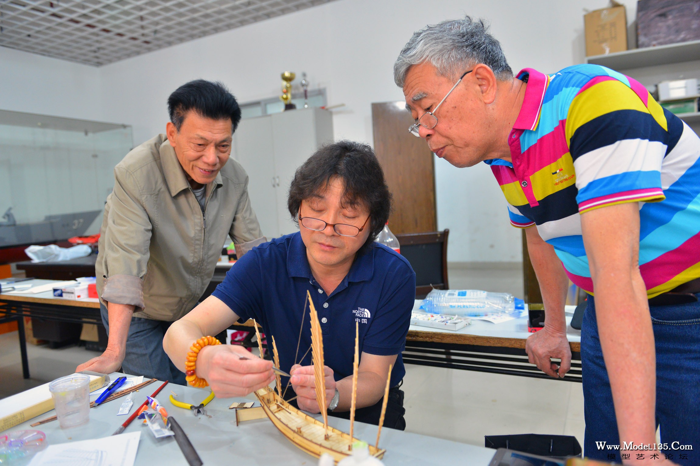 姜招银老师正在演示沙船模型的制作